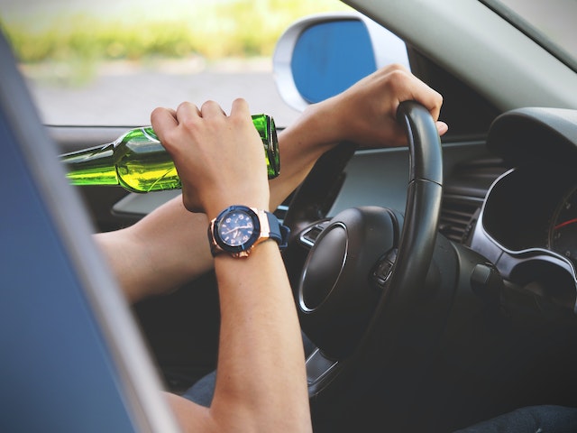 driver drinking bottle of beer
